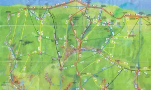 Mapa turystyczna Karkonoszy z zaznaczonymi szlakami. Kolorowe linie pokazują różne szlaki, a cyfry czas przejścia. Idealna do planowania wędrówek po Karkonoszach.