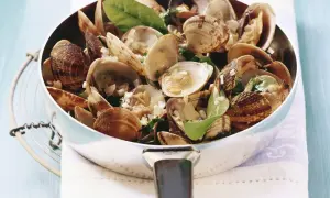 Frisch zubereitete vongole deutsch in einer Pfanne, garniert mit Kräutern und Knoblauch. Ein Genuss!