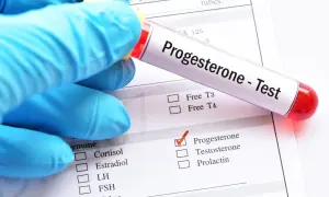 Rękawiczka w niebieskiej rękawiczce trzyma probówkę z napisem "Progesterone - Test". Zaznaczono pole "Progesterone" na formularzu.