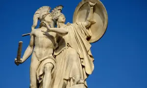 Kamienna rzeźba przedstawia dwóch wojowników w hełmach. Jeden z nich, młody mężczyzna, trzyma miecz. Drugi, w zbroi i z tarczą, zdaje się go chronić. To symboliczny obraz walki i odwagi, być może nawiązujący do boga wojny Aresa.