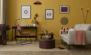 Un soggiorno con pareti color ocra e arredi che creano abbinamenti caldi e accoglienti.
