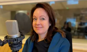Anna Borg ler mot kameran i en inspelningsstudio, med en mikrofon framför sig.