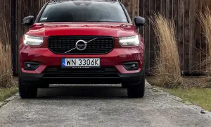 Czerwone Volvo XC40 na podjeździe. Zbliżenie na przód auta, gdzie widoczne są światła, grill i tablica rejestracyjna. Poznaj volvo xc40 wymiary.