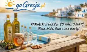 Oliwa, miód, ouzo – co przywieźć z Grecji? Pamiątki z wakacji na drewnianym stole z widokiem na grecką wyspę.