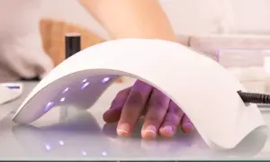 Dłoń pod lampą LED 48W, utwardzanie żelu. Ile utwardzać żel w lampie led 48w? Czas zależy od produktu.