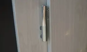 Metalowy zawias drzwiowy, widoczna regulacja zawiasów drzwi.