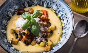 Cremige Polenta mit gebratenem Gemüse, Parmesan und Basilikum. Was ist Polenta? Ein herzhaftes Gericht aus Maisgrieß.