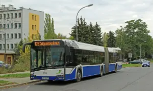 Autobus linii 125 odjeżdża za 9 minut. Długi, przegubowy pojazd stoi na przystanku obok budynku mieszkalnego.