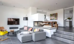 Modernes split-level Haus mit offenem Wohnbereich, Kamin, Essbereich und stilvoller Einrichtung.