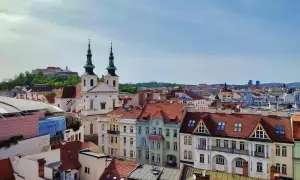 Widok na dachy Brna, w tym kościół z zielonymi wieżami i zamek na wzgórzu. Idealne miejsce, by zobaczyć, co w Brnie warto zobaczyć.
