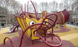 Un parque infantil con forma de dragón amarillo y rojo en Usera. ¡Un lugar genial que ver en Usera para los niños!