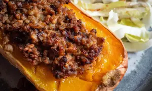 Moitié de courge butternut farcie, une recette savoureuse avec une garniture dorée et croustillante, servie avec une salade fraîche.