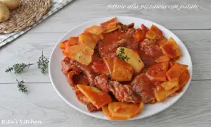 Piatto di fettine di carne in salsa pizzaiola con patate a fette, guarnito con timo fresco.