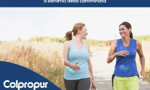 Due donne sorridono mentre camminano su un sentiero, godendosi i benefici della camminata.