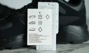 Czarny but sportowy z metką, na której widnieje symbol skóry naturalnej, wskazujący na wysoką jakość materiału.