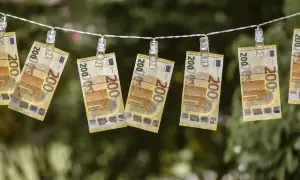 Banconote da 200 euro stese ad asciugare, un modo visivo per chiedersi quanto costa una busta paga.