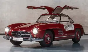 Czerwony Mercedes 300 SL z otwieranymi do góry drzwiami, prezentujący swoje klasyczne piękno.