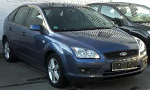 Ford Focus azul con posible fallo sistema motor. Aparcado junto a otro coche negro.