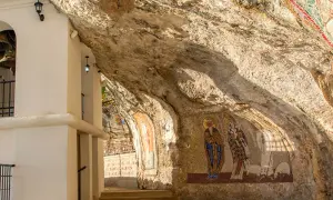 W skalnych niszach monasteru Ostrog widnieją mozaiki świętych. Biała architektura kontrastuje z surową skałą.