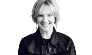 Uśmiechnięta Brené Brown w skórzanej kurtce, uosobienie odwagi i autentyczności.