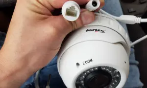 Dłoń trzyma białą kamerę IP z logo "fortec for vision". Widać złącze RJ45 i zasilania. Dowiedz się, jak podłączyć kamerę bez rejestratora.