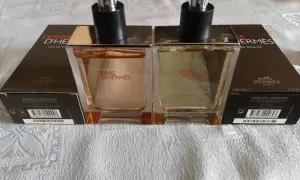Dwa flakony Terre d'Hermès EDT, każdy 100 ml, stoją na białym obrusie.