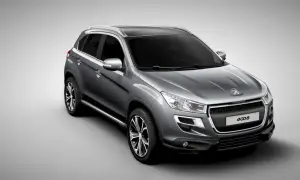 Szary crossover Peugeot 4008 z czarnym dachem i srebrnymi relingami, widok z przodu i z boku.
