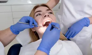 Dentysta bada zęby pacjentki. Czy plomba może wypaść? Specjalista ocenia stan uzębienia.