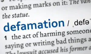 Słownikowa definicja "defamation" (zniesławienia), opisująca szkodzenie komuś przez mówienie lub pisanie złych rzeczy. Uważaj na pomówienia w pracy.