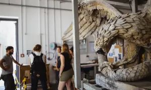 Studierende im Restaurationsstudium betrachten eine detailreiche Skulptur eines geflügelten Wesens.