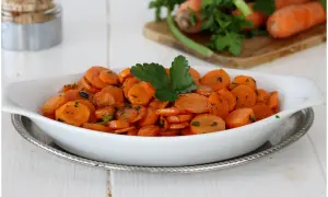 Carote in padella, dolci e saporite, guarnite con prezzemolo fresco. Un contorno semplice e gustoso.