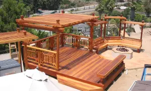 Terraza de madera de secuoya con pérgolas, bancos y hoguera. Un espacio ideal para disfrutar al aire libre.