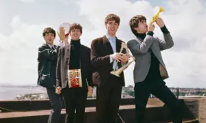 The Beatles grają na instrumentach, tworząc piosenki. George gra na trąbce, John na harfie, Paul na tamburynie, a Ringo ma bębenek na szyi.
