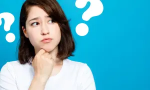 Junge Frau mit nachdenklichem Blick, die sich am Kinn kratzt. Mehrere Fragezeichen deuten auf ihre fünf head move-Gedanken hin.