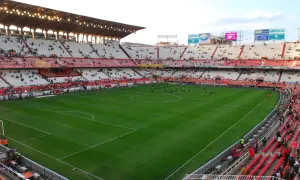 Piłkarze rozgrzewają się na murawie stadionu Sevilla. Widownia zajmuje miejsca na czerwono-białych trybunach.