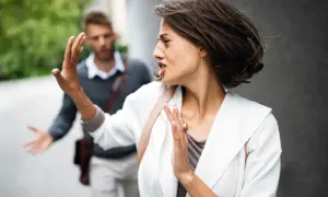 Kobieta odpycha mężczyznę, gestem sugerującym brak zaufania. Jak budować zaufanie w związku, gdy pojawia się konflikt?