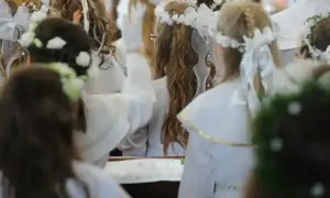 Dzieci w bieli, z wiankami na głowach, czekają na komunię. Zastanawiasz się, ile daje się na komunię?