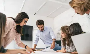 Equipo colaborando en un proyecto, demostrando un alto coeficiente emocional al comunicarse y resolver problemas juntos.