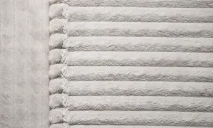 Miękki, prążkowany materiał mikrofibra w jasnym kolorze.