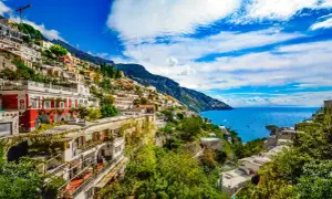 Positano, z czego słyną Włochy: kolorowe domy na zboczu góry, błękitne morze i łodzie.
