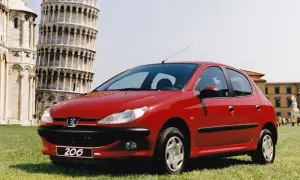 Czerwony Peugeot 206 na tle Krzywej Wieży w Pizie.