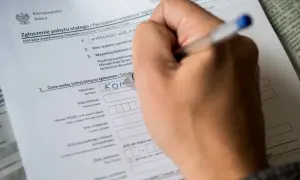 Ręka wypełnia formularz "Zgłoszenie pobytu stałego". Czy jest obowiązek meldunku? Tak, ten dokument to potwierdza.
