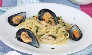 Spaghetti con le cozze in bianco, un piatto semplice e gustoso, con cozze fresche e prezzemolo tritato.