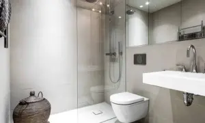 Moderno bagno senza finestra con doccia a filo pavimento, WC sospeso, lavabo minimalista e cesto in vimini.