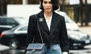 Elegancka kobieta w tweedowej marynarce i jeansach, z torebką Chanel. Klasyczne coco chanel stylizacje.