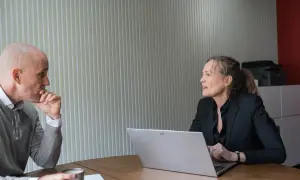 Man en vrouw in gesprek, oefenen gesprekstechnieken lastige mensen. De man denkt na, de vrouw legt uit.