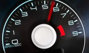 Tacómetro de un coche diésel mostrando altas revoluciones. La aguja roja apunta entre 5 y 6, indicando un motor acelerado.