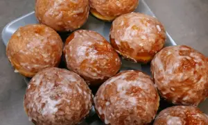 Pyszne, rumiane pączki z piekarnika, oblane lukrem, kuszą swoim wyglądem. Idealne na tłusty czwartek!