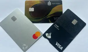 Trzy karty płatnicze: srebrna z logo Mastercard, czarna z logo Visa Credit Platinum i złota z logo Banku Polskiego.