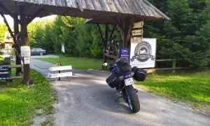 Motocykl czeka na dalszą podróż po Słowacji. Przy drogowskazie "100m parking" i znaku "Bieszczadzka Przystań Motocyklowa" zaczyna się przygoda.